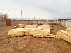 Домокомплект на участке, готовится древесина для каркаса.